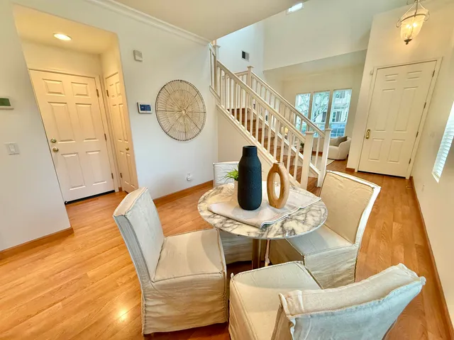 a view of a dining room with furniture a potted plant and wooden floor