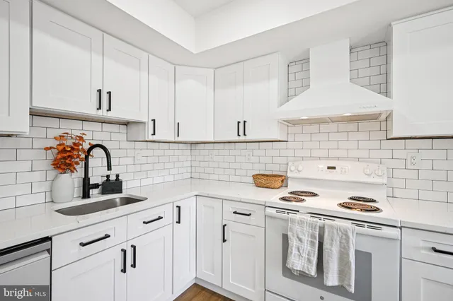a kitchen with white cabinets a sink and white appliances