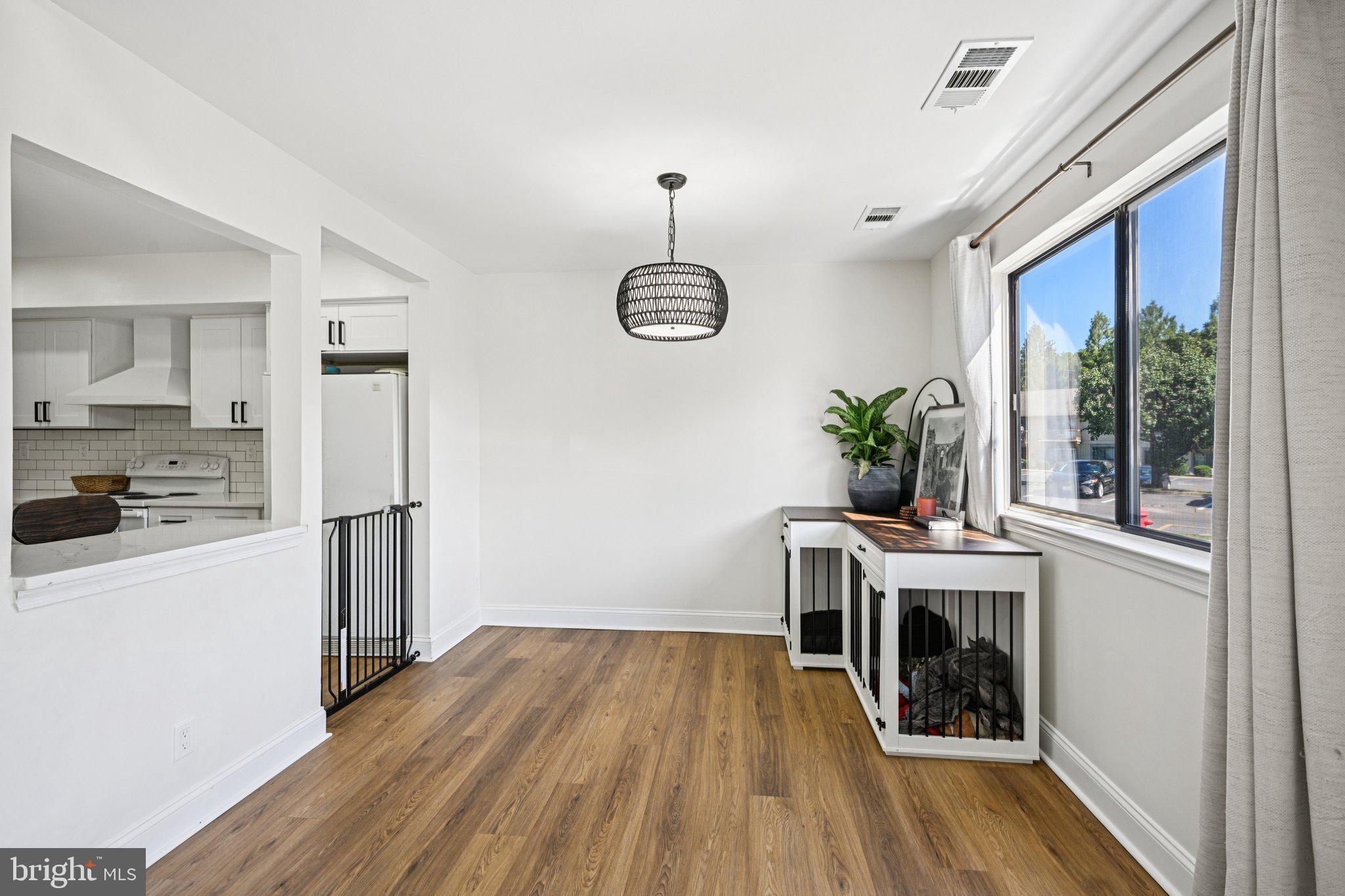 115 East Kings Highway, Unit 319 Maple Shade, NJ 08052 - Photo 9 of 37 a dining room with wooden floor a chandelier a wooden table and chairs