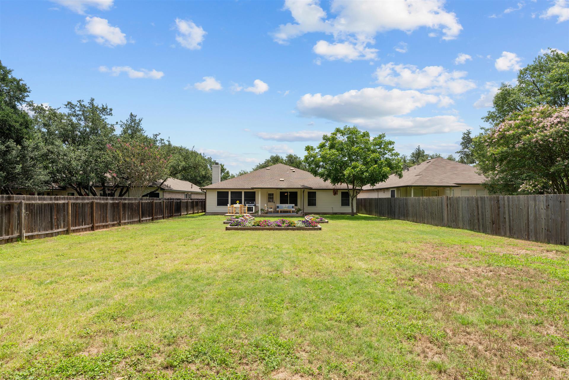 4725 Tello Path Austin, TX 78749 - Photo 2 of 34 A fenced backyard with vibrant landscaping offers ample space for outdoor enjoyment.