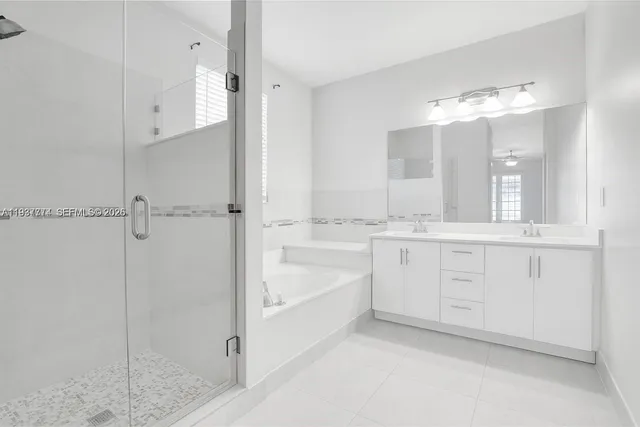 a en suite bathroom with a granite countertop sink mirror and a bathtub