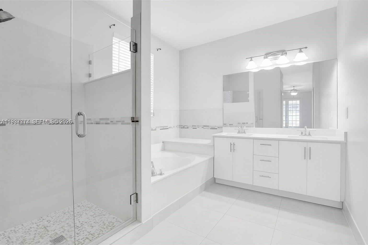 797 Chimney Rock Road, Unit 797 Weston, FL 33327 - Photo 18 of 26 a en suite bathroom with a granite countertop sink mirror and a bathtub