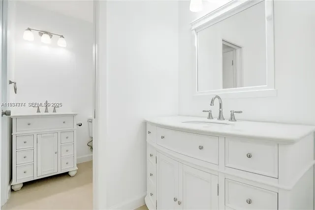 a bathroom with a sink vanity and mirror