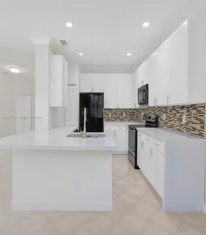 a kitchen with stainless steel appliances kitchen island granite countertop a stove and a sink