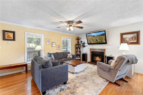 a living room with furniture a fireplace and a flat screen tv