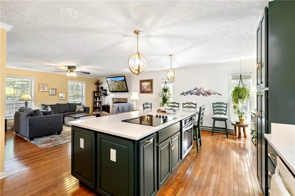 a kitchen with a stove and wooden floor