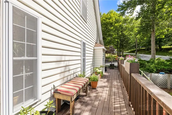a view of a patio with table and chairs and potted plants with wooden floor and fence