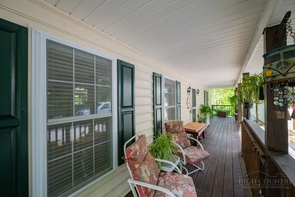 a view of a porch with furniture and a yard