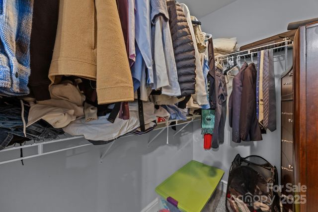 a view of walk in closet with clothes and shoes
