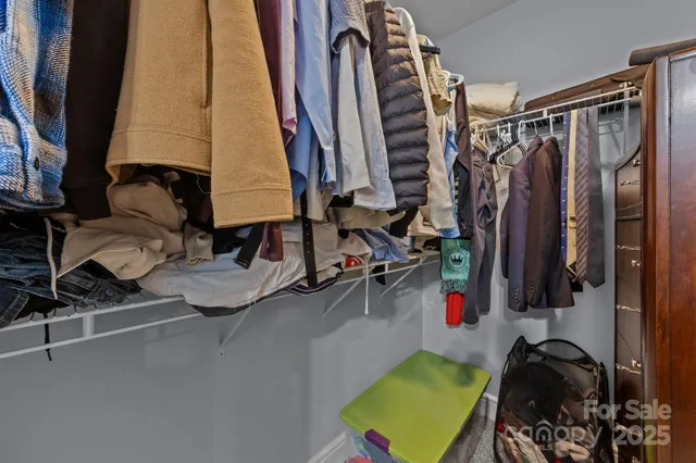 a view of walk in closet with clothes and shoes