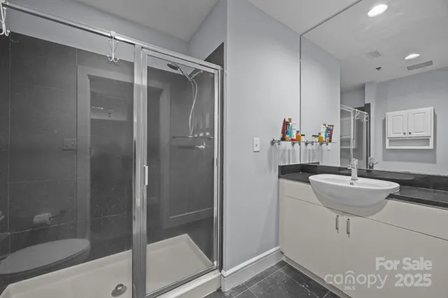 a bathroom with a granite countertop sink a toilet and shower