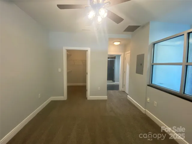 an empty room with closet and fan