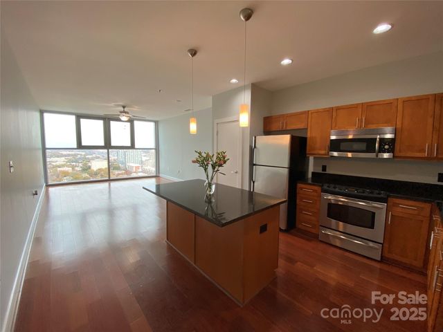 a kitchen with stainless steel appliances granite countertop a refrigerator a sink and a stove