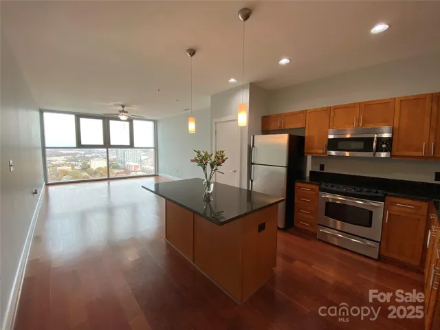 a kitchen with stainless steel appliances granite countertop a refrigerator a sink and a stove