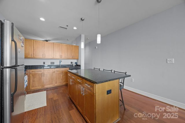 a kitchen with granite countertop a sink a counter space and stainless steel appliances