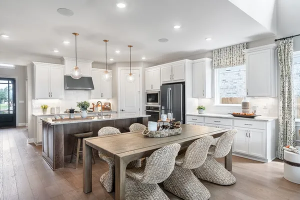 a kitchen with kitchen island granite countertop a sink and a refrigerator