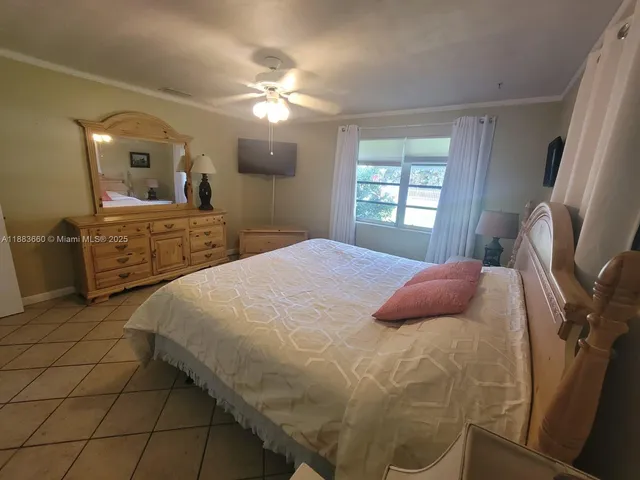 a bedroom with a bed a mirror and window