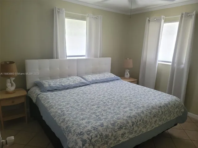a large bed sitting in a bedroom next to a window