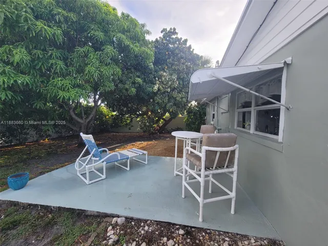 a view of a patio with table and chairs and potted plants with wooden floor and fence