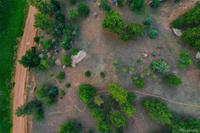 an aerial view of a yard with a lot of flower plants and wooden fence