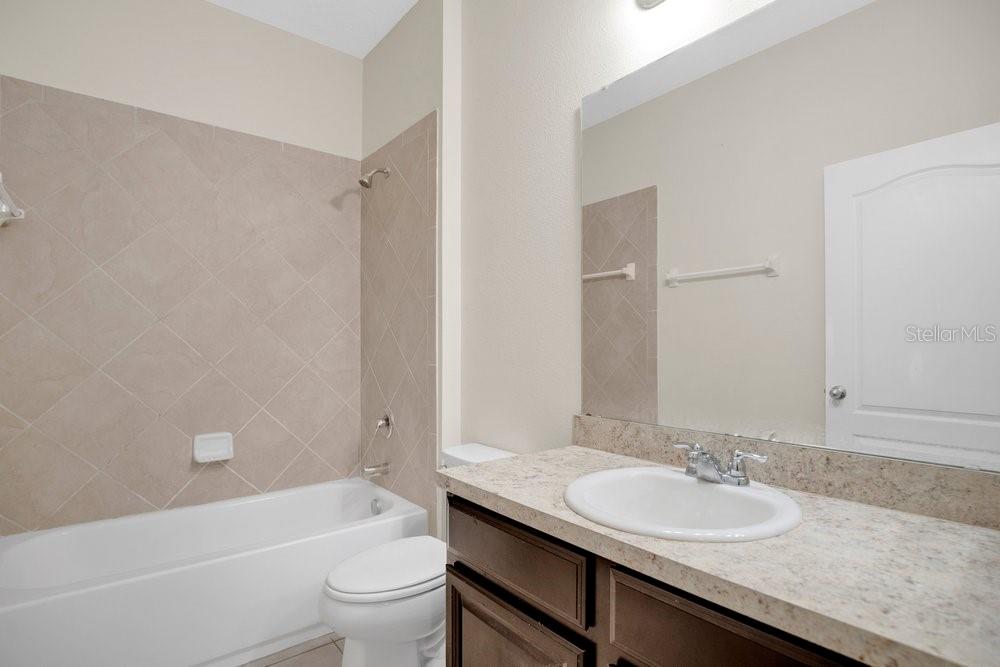 680 Preakness Circle Deland, FL 32724 - Photo 18 of 28 a bathroom with a granite countertop sink a toilet and shower