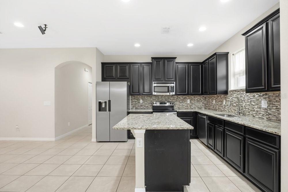 680 Preakness Circle Deland, FL 32724 - Photo 10 of 28 a kitchen with stainless steel appliances granite countertop a sink stove and refrigerator