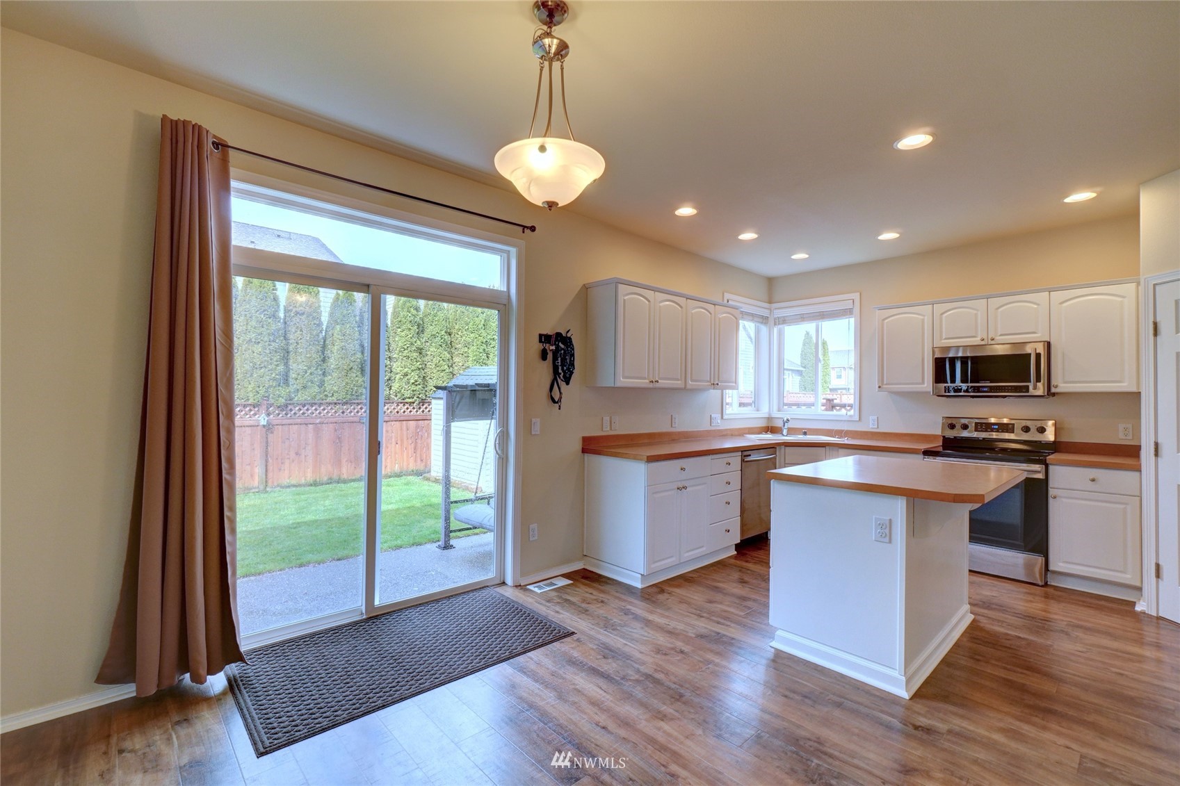 7053 Radius Loop Southeast Lacey, WA 98513 - Photo 13 of 34 a kitchen with stainless steel appliances granite countertop a refrigerator a sink dishwasher a stove and white cabinets with wooden floor