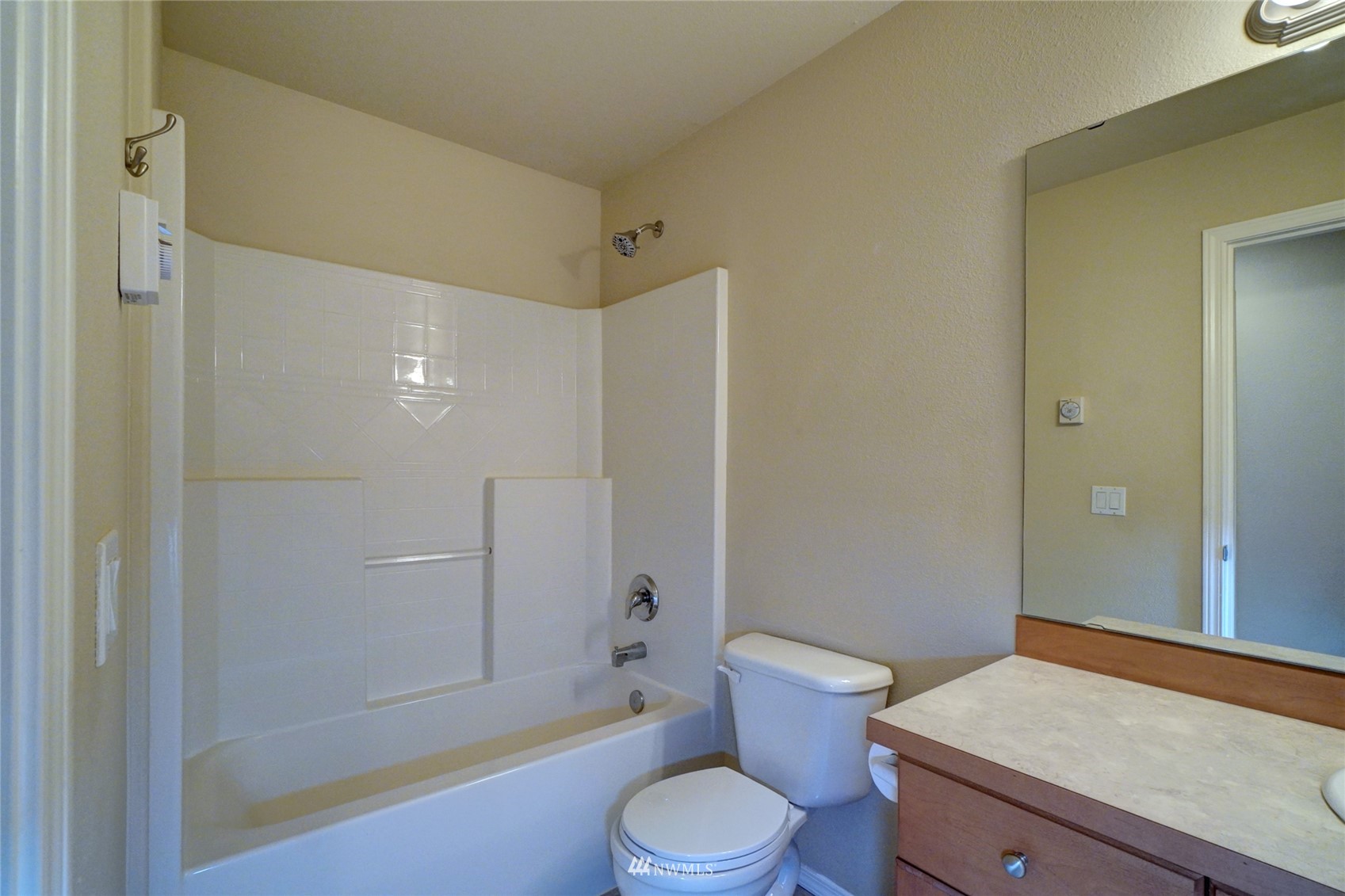 7053 Radius Loop Southeast Lacey, WA 98513 - Photo 30 of 34 a bathroom with a granite countertop toilet a sink and shower