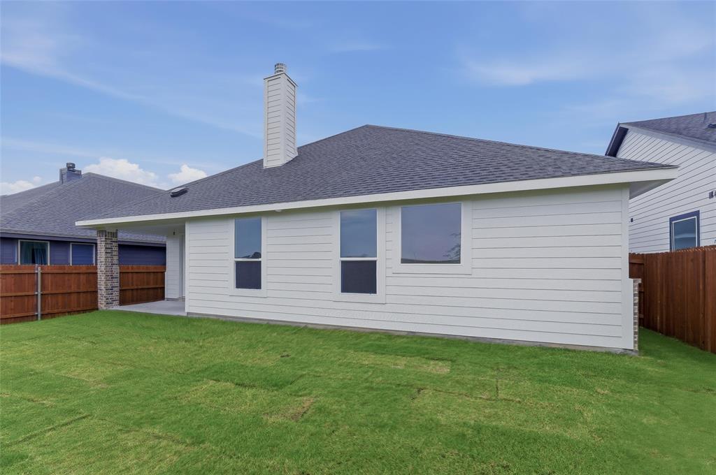 1329 Frio Drive Springtown, TX 76082 - Photo 24 of 25 White horizontal siding exterior with a dark shingle roof, featuring a tall chimney and multiple windows