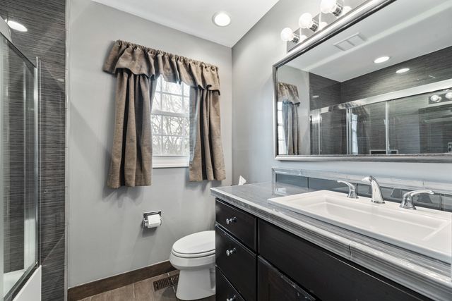 a bathroom with a sink a toilet and mirror