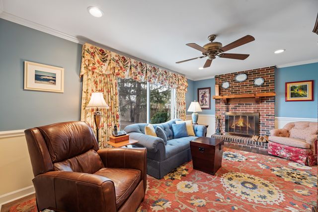 a living room with furniture a large window and a fireplace