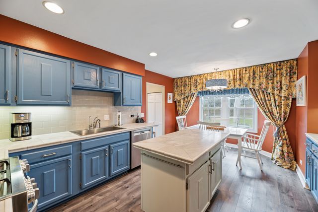 a kitchen with a sink a stove a refrigerator and wooden cabinets