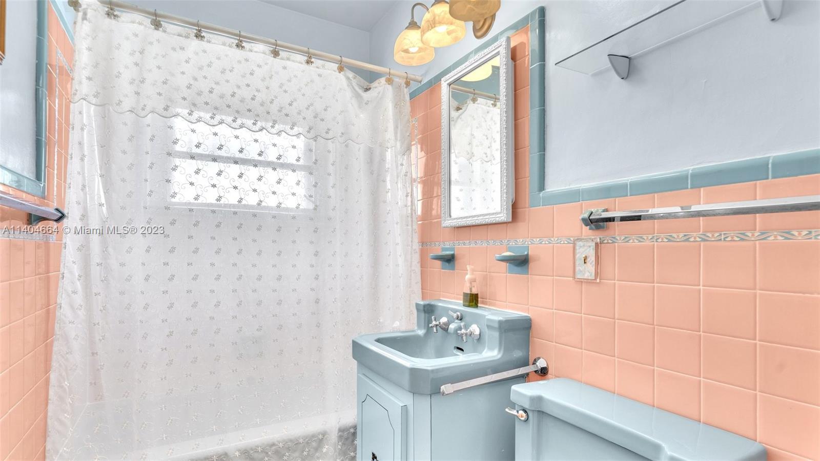 3333 Southwest 1st Street Miami, FL 33135 - Photo 11 of 70 a bathroom with a sink a toilet and a shower curtain