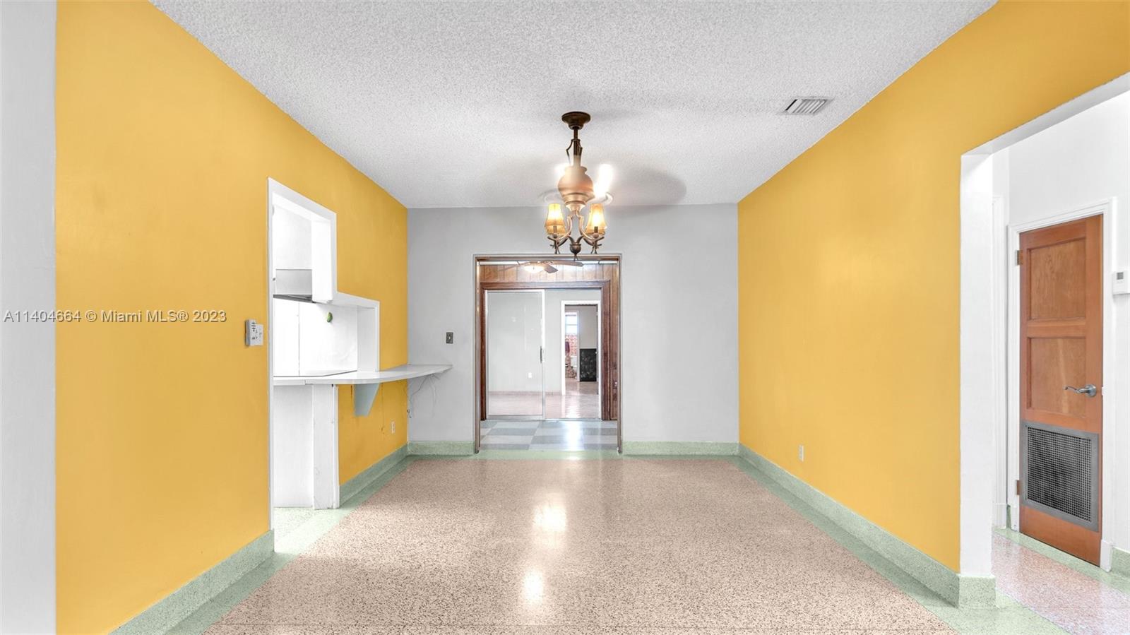 3333 Southwest 1st Street Miami, FL 33135 - Photo 52 of 70 a view of a hallway with a dining table and a chandelier