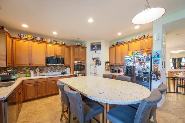 a living room with a couch a flat screen tv and a refrigerator