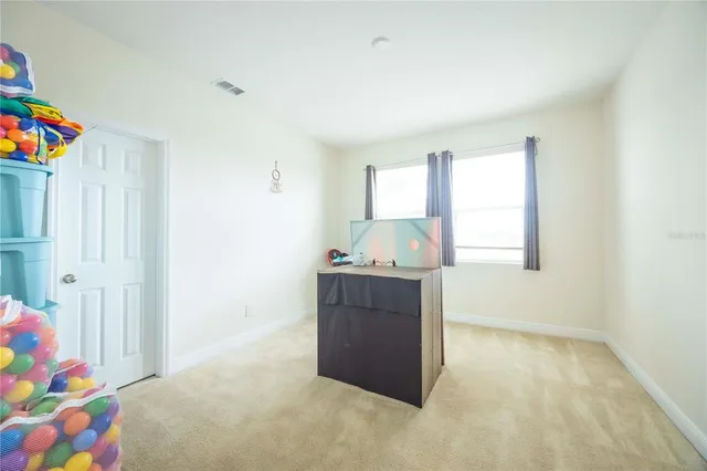 a bedroom with a bed window and a flat screen tv