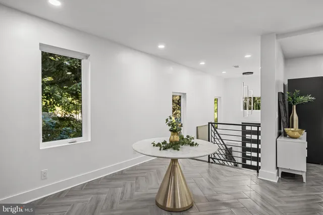 a view of a hallway with wooden floor and staircase