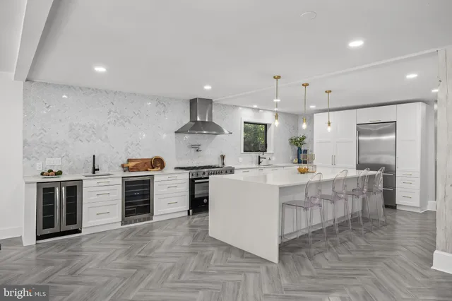 a kitchen with lots of counter space a sink appliances and a large window