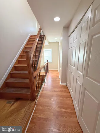 a view of staircase with wooden floor and white walls