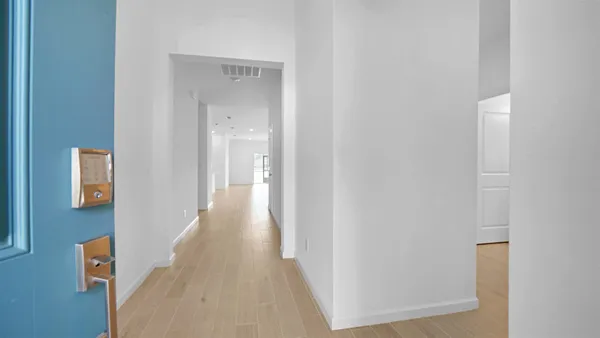 a view of a hallway with wooden floor