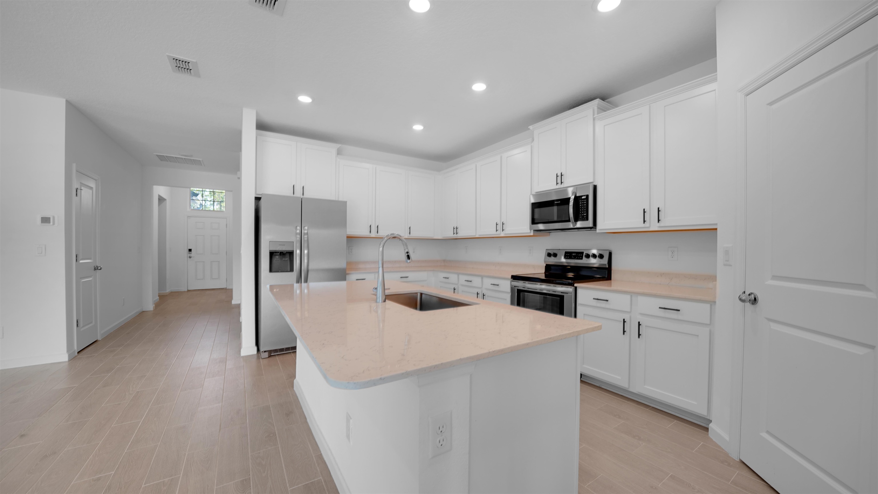 264 Lake Sinclair Street St. Augustine, FL 32084 - Photo 8 of 40 a kitchen with white cabinets and stainless steel appliances