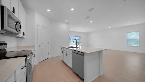 a kitchen with a sink appliances and cabinets