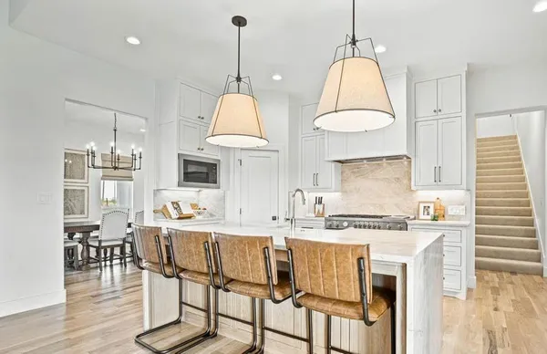 a dining table chairs window and white cabinets