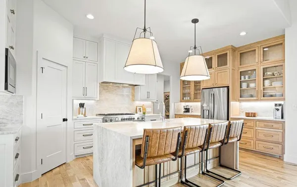 a kitchen with stainless steel appliances granite countertop a sink a stove and a refrigerator