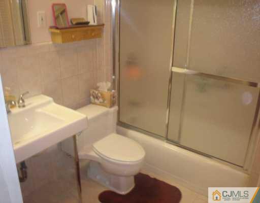 13 Meyer Road Edison, NJ 08817 - Photo 3 of 8 a bathroom with a sink a toilet and shower