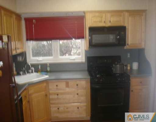 13 Meyer Road Edison, NJ 08817 - Photo 4 of 8 a kitchen with a microwave a stove and a microwave