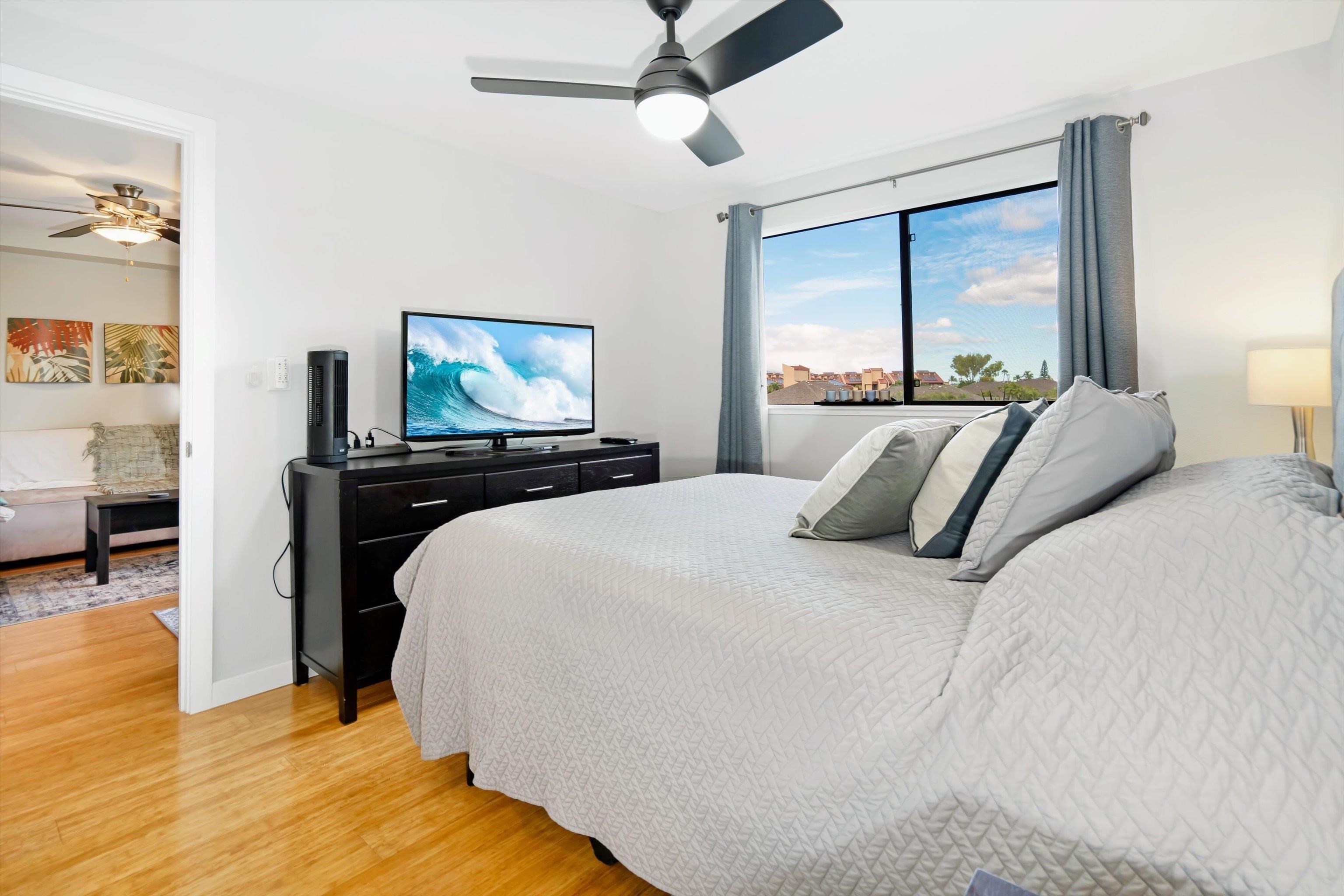 2747 South Kihei Road, Unit B203 Kihei, HI 96753 - Photo 21 of 44 a bedroom with a bed and a chandelier