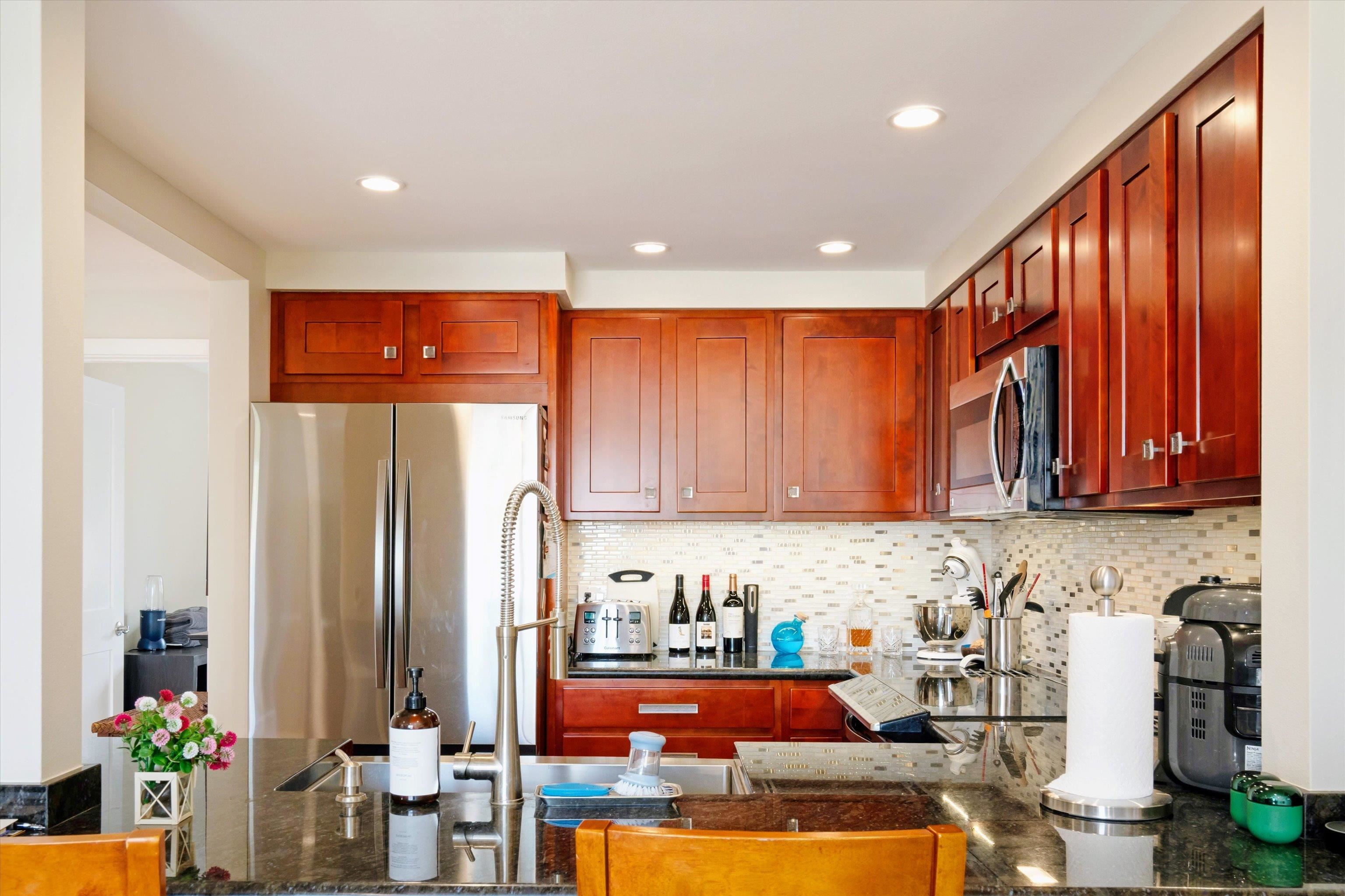 2747 South Kihei Road, Unit B203 Kihei, HI 96753 - Photo 29 of 44 a kitchen with stainless steel appliances granite countertop a refrigerator and a stove top oven
