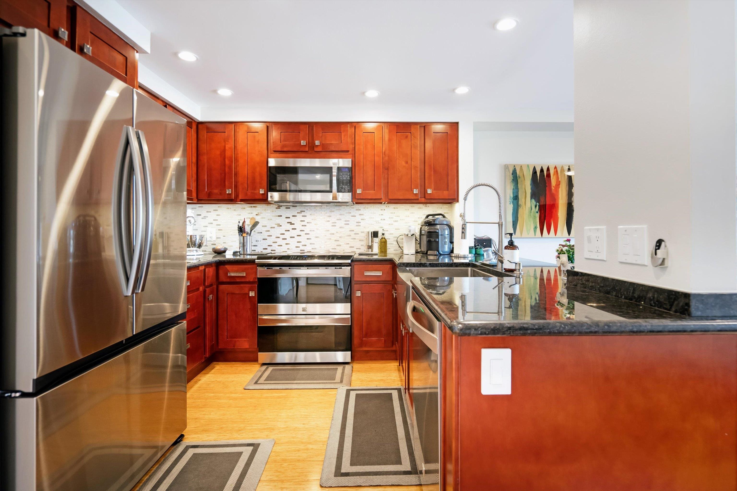 2747 South Kihei Road, Unit B203 Kihei, HI 96753 - Photo 7 of 44 a kitchen with stainless steel appliances granite countertop a refrigerator a stove and a sink