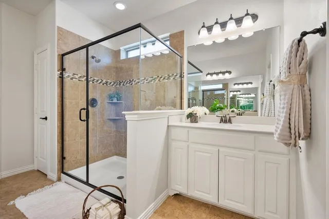 a bathroom with a double vanity sink mirror and shower